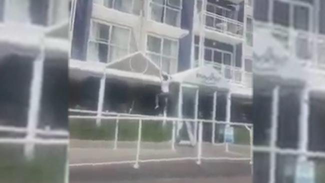 An image from the video of a woman climbing down the side of a hotel, allegedly busting out of quarantine. Picture: Facebook