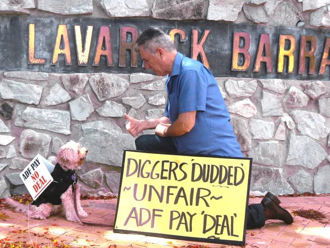 Protesting over effective pay cut ... Retired Colonel Ray Martin with Olly, the Activist Dog, outside the Army’s Lavarack Barracks in Townsville.