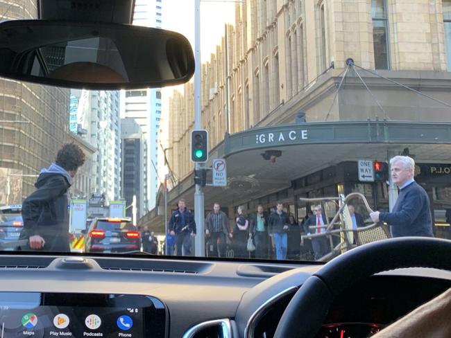 A hero bystander holds a chair out to stop a knifeman on Clarence St in Sydney on Tuesday afternoon. Picture: Twitter / @Ayusha77