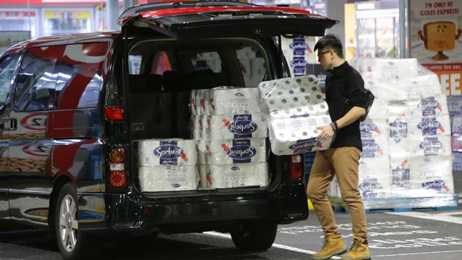 A man loads up his van with toilet paper at a Coles Express petrol station in the Sydney suburb of Five Dock. Picture: Bill Hearne