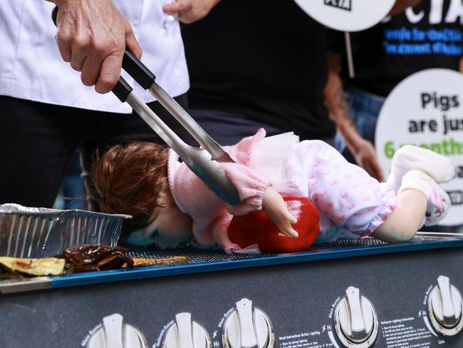 SYDNEY, AUSTRALIA - NCA NewsWire Photos - 05 APRIL, 2023: PETA Protesters, at Pitt Street Mall, Sydney, today, barbecuing a baby doll to Urge Aussies to ÃLeave Babies off the BBQÃ. Picture: NCA NewsWire / Justin Lloyd