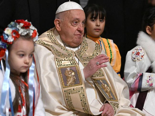 Pope Francis is surrounded by children at the end of the Christmas Eve mass at The St Peter's Basilica in the Vatican on December 24, 2024. Pope Francis marks Christmas Eve with a special ceremony launching Jubilee 2025, a year of Catholic celebrations set to draw more than 30 million pilgrims to Rome. Over the next 12 months, pilgrims will pass through the large and imposing bronze door, which is normally closed, by tradition benefiting from a "plenary indulgence", a type of forgiveness for their sins. (Photo by Tiziana FABI / AFP)