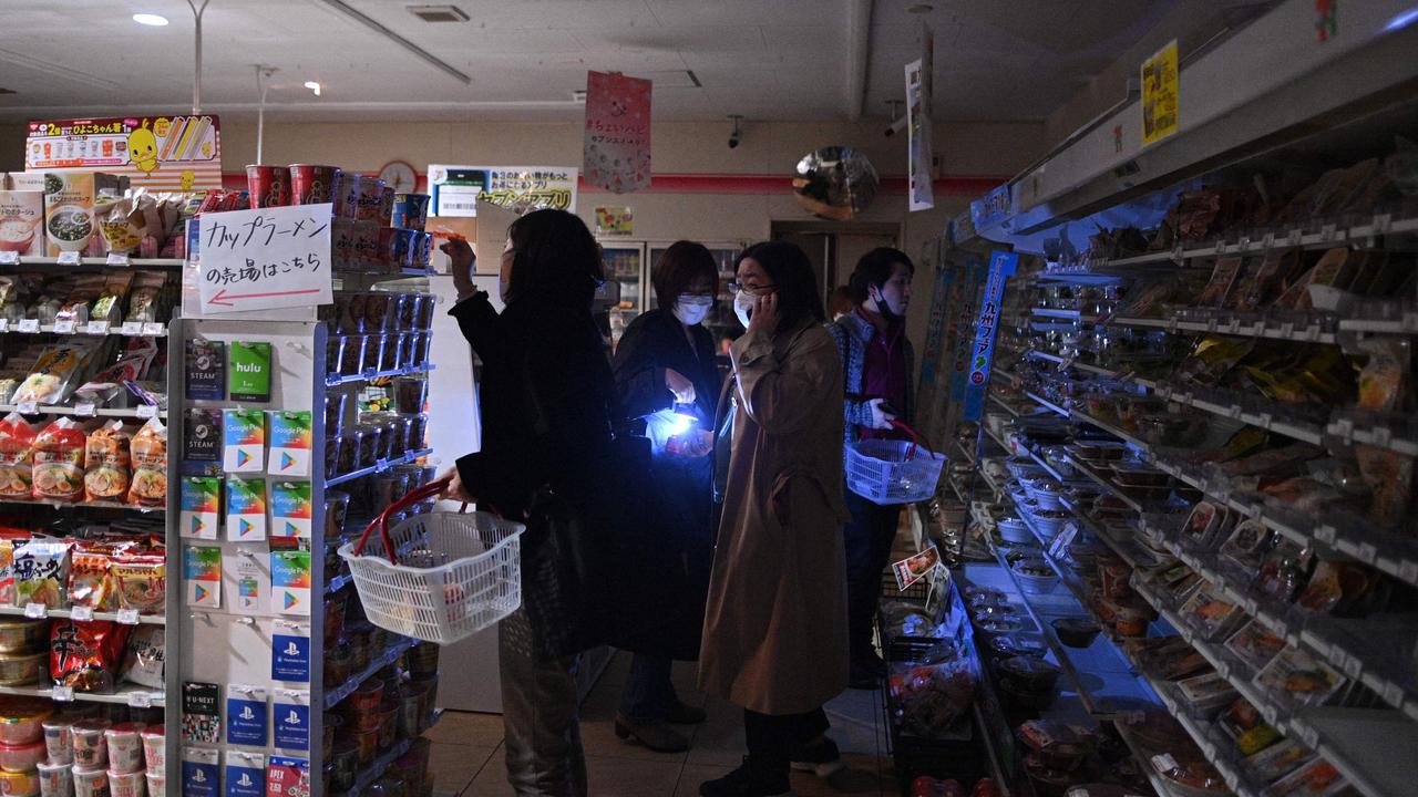 People shop in a store in a residential area during a power outage in Koto district in Tokyo. Picture: AFP