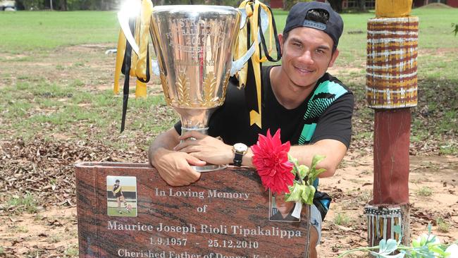 Daniel Rioli at the grave of his great uncle, Richmond legend Maurice Rioli during the cup’s visit to the Tiwi Islands. Picture: Michael Klein