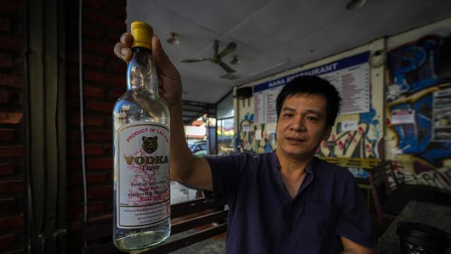 Duong Duc Toan, the manager of Nana Backpack hostel, holds up a bottle of vodka at the hostel. He has been arrested over the deaths. Picture: AP