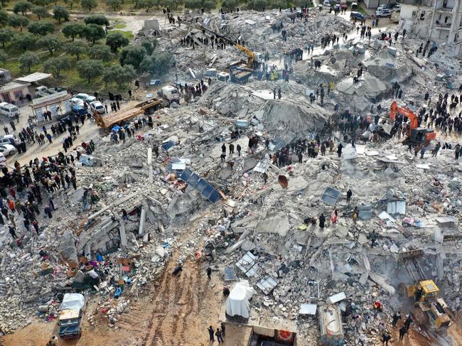 This aerial view shows residents searching for victims and survivors amid the rubble of collapsed buildings following an earthquake in the village of Besnia near the town of Harim, in Syria. Picture: AFP