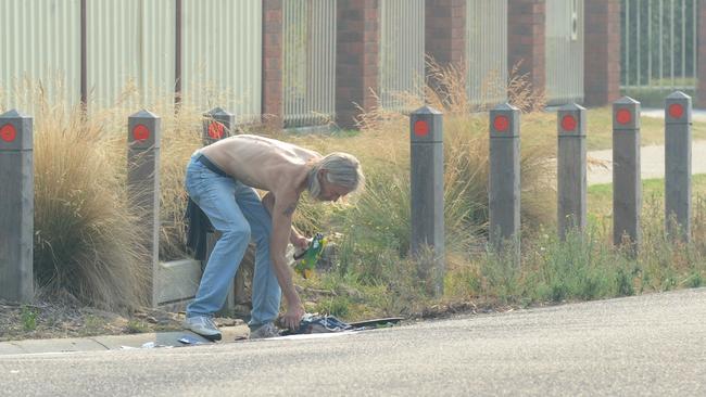 A local resident helps clean up debris at the scene. Picture: Andrew Henshaw