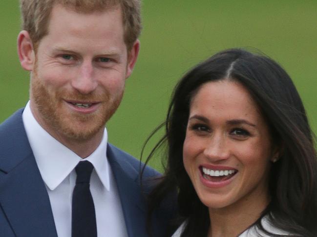 (FILES) This file photo taken on November 27, 2017 shows Britain's Prince Harry standing with his fiancée US actress Meghan Markle whilst they pose for a photograph in the Sunken Garden at Kensington Palace in west London, following the announcement of their engagement. Britain's Prince Harry and US actress Meghan Markle will marry on May 19 at St George's Chapel in Windsor Castle near London, Kensington Palace said on December 15, 2017. / AFP PHOTO / Daniel LEAL-OLIVAS