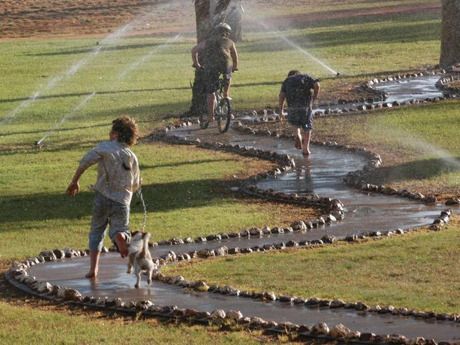 Charleville children running through the sprinklers at Graham Andrews Parklands. The State in the grip of a severe drought yet the township is drought proof due to the Great Artesian Basin. Photo: David Martinelli.