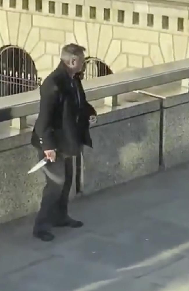 In this grab taken from video made available by @HLOBlog, a bystander holds the knife he has taken from a suspected terrorist. Picture: @HLOBlog via AP