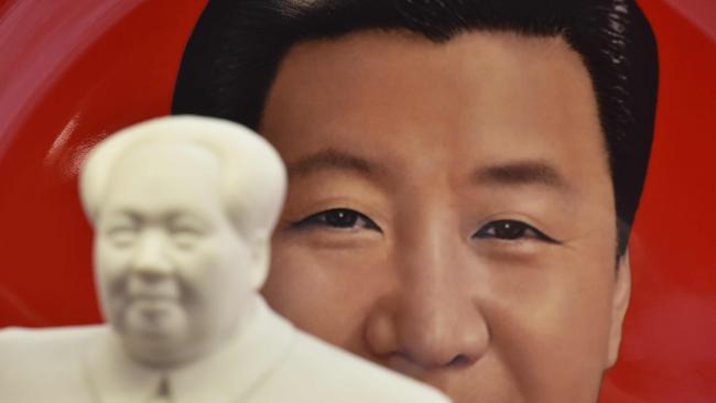 A decorative plate featuring an image of Chinese President Xi Jinping is seen behind a statue of late communist leader Mao Zedong. Picture: Greg Bake/AFP