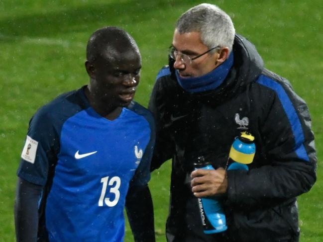 France's defender N'golo Kante (L) is comforted by a coaching staff member after he was substituted during the FIFA World Cup 2018 qualifying football match between Bulgaria and France at The Vasil Levski Stadium in Sofia on October 7, 2017. / AFP PHOTO / Nikolay DOYCHINOV