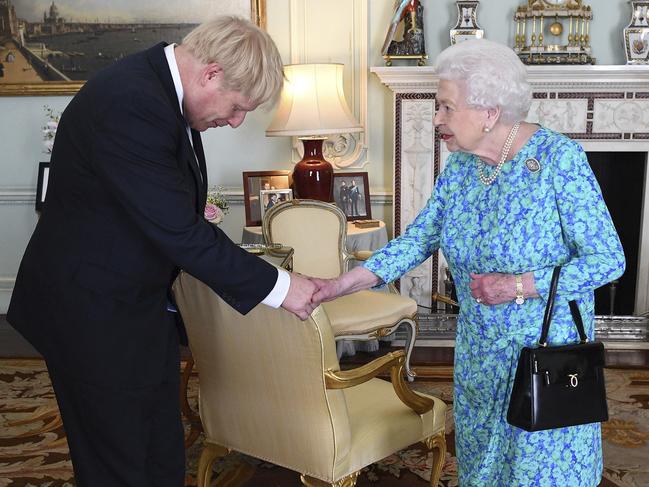 Britain's Queen Elizabeth II welcomes newly elected leader of the Conservative party Boris Johnson during an audience at Buckingham Palace, London, Wednesday July 24, 2019, where she invited him to become Prime Minister and form a new government. (Victoria Jones/Pool via AP)