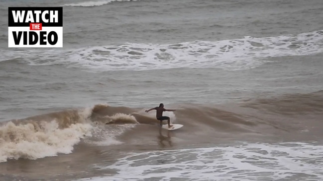 Surfers catch some swell at Nightcliff Beach