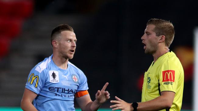 Melbourne City captain Scott Jamieson of Melbourne City speaks to referee Alex King during the FFA Cup final against Adelaide United. The new FIFA laws of the game were used for the clash. (AAP Image/Kelly Barnes)