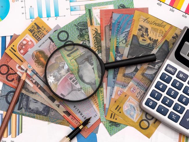 Business graphs with australian dollars, magnifier, pen and calculator Australian money tax generic