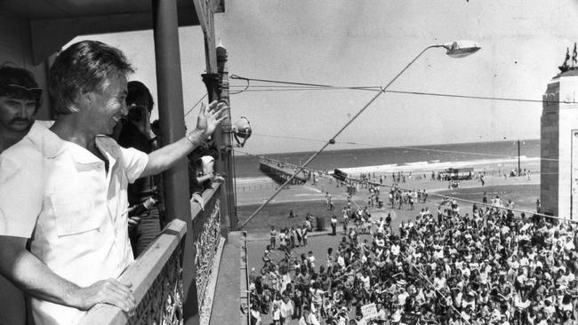 Former SA Premier Don Dunstan on the balcony of the Pier Hotel at Glenelg smiles and greets the huge crowd of people below, who gathered in anticipation of a tidal wave, predicted by clairvoyant John Nash in 1976.