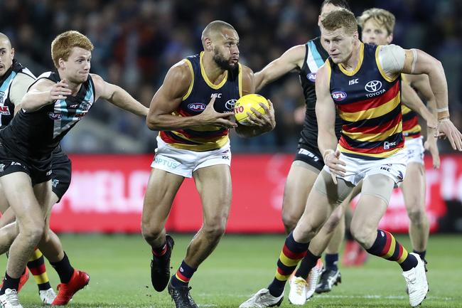 Adelaide’s Cameron Ellis-Yolmen gets the ball out between Port Adelaide’s Willem Drew and Crows Reilly O’Brien in Showdown 46 at Adelaide Oval. Picture Sarah Reed