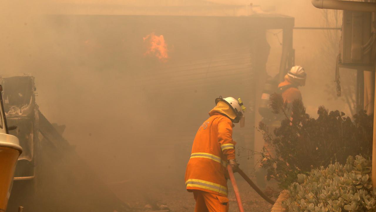 CFS firefighters put out fires on Jacaranda Drive at Woodside in the Adelaide Hills. Picture: AAP/Kelly Barnes