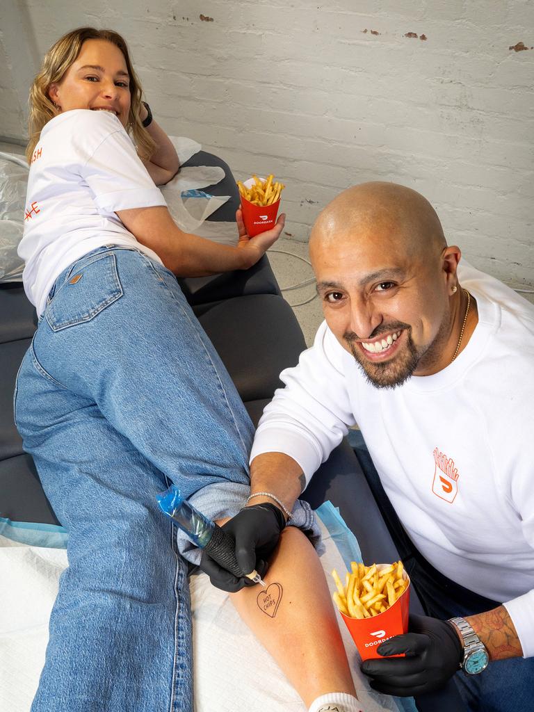 Cholo Caracciolo gives Michelle Easson a tattoo for International Fries Day. Picture: Mark Stewart