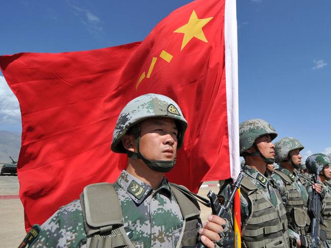 (FILES) In this file photo taken on September 19, 2016, a Chinese soldier holds a Chinese flag during Peace Mission-2016 joint military exercises of the Shanghai Cooperation Organization (SCO) in the Edelweiss training area in Balykchy, some 200 km from Bishkek. - During Xi Jinping's decade-long rule China has built the world's largest navy, revamped the world's largest standing army and amassed a nuclear and ballistic arsenal to trouble any foe. (Photo by Vyacheslav OSELEDKO / AFP)