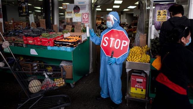 A worker manages the flow of the customers at a food market in the Jackson Heights neighbourhood of Queens, New York. Picture: AFP