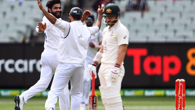 India Ravi Jadeja (L) and Ajinkya Rahane (C) celebrate dismissing Australia's Matthew Wade (R) on the third day of the second cricket Test match between Australia and India at the MCG in Melbourne on December 28, 2020. (Photo by WILLIAM WEST / AFP)