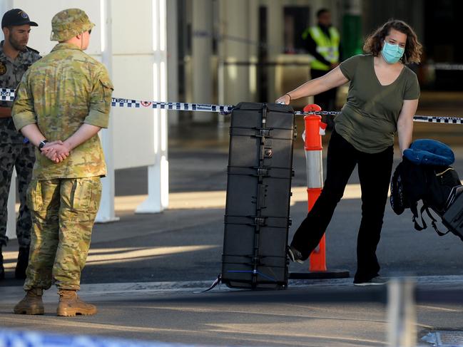 New arrivals at Sydney International airport are ushered into waiting buses for hotel quarantine.  Photo Jeremy Piper