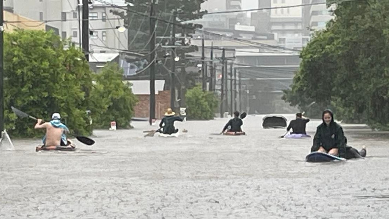 Neighbours paddle down a Windsor street on Sunday afternoon. Picture: Felicity Ripper