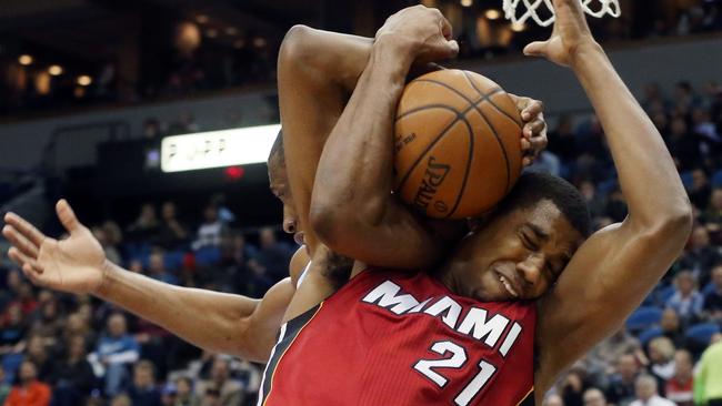 Minnesota Timberwolves’ Andrew Wiggins, left, and Miami Heat’s Hassan Whiteside (21) struggle for possession of a rebound.