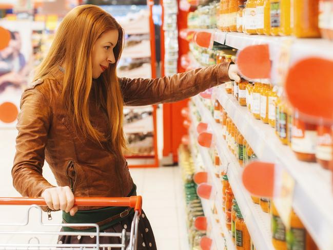 Woman buying sauce in supermarket