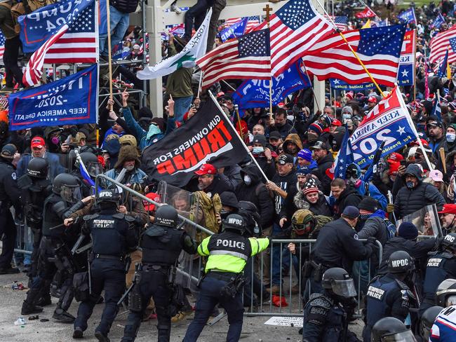 In this file photo taken on January 06, 2021, Trump supporters battle with police and security forces as they storm the US Capitol building in Washington, DC. - President Joe Biden slammed his predecessor Donald Trump Monday in a prerecorded video address to The National Organization of Black Law Enforcement Executives (NOBLE) for watching his supporters riot for hours on January 6 while police at the US Capitol suffered through a "medieval hell." (Photo by ROBERTO SCHMIDT / AFP)