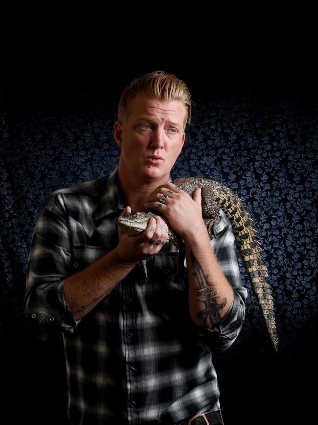 2017: Queens of the Stone Age frontman Josh Homme gets friendly with a crocodile on his visit to Darwin. Picture: Elise Derwin