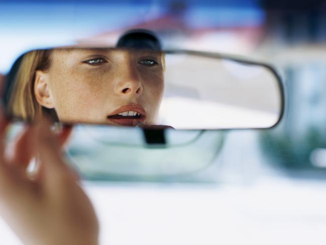 Teenage girl looking in her rear view mirror. Back Seat driver. driving. woman. stock image. Picture: ThinkStock