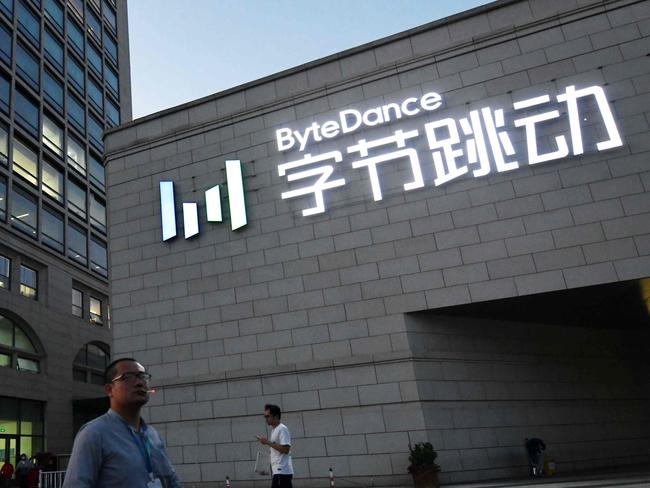 People walk past the headquarters of ByteDance, the parent company of video sharing app TikTok, in Beijing on September 16, 2020. - Silicon Valley tech giant Oracle is "very close" to sealing a deal to become the US partner to Chinese-owned video app TikTok to avert a ban in the United States, President Donald Trump said on September 15. (Photo by GREG BAKER / AFP)