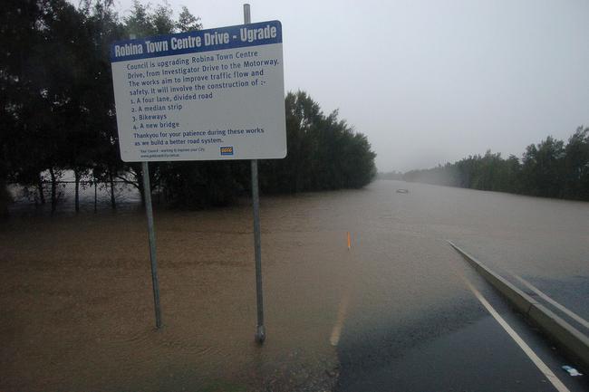 Gold Coast, June 30, 2005. Flood waters and a submerged vehicle at Robina on Queensland’s Gold Coast today. Widespread flooding has hit the popular tourist area, known for its sunshine and sandy beaches, with reports of rainfall reaching 80mm per hour in some regions. (AAP Image/Tony Phillips)