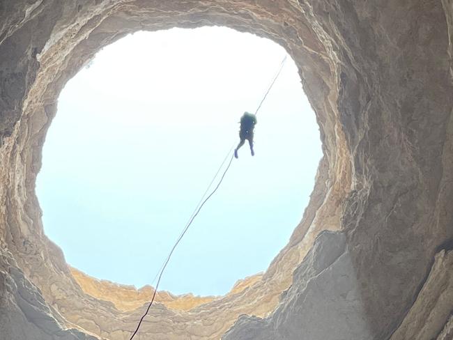 A handout picture taken by the Oman Cave Exploration Team on September 15, 2021, shows one of the team's cavers abseiling down the Barhout well, a sinkhole known as the 