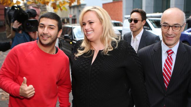 A fan gets his picture with Rebel Wilson as she arrives at Melbourne’s Supreme Court. Picture: David Crosling, AAP