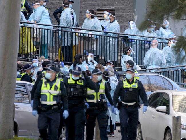 Police and healthcare workers at the locked-down North Melbourne public housing. Picture: Andrew Henshaw