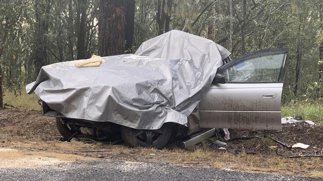 The vehicle, which collided with a tree on Pringles Way, Lawrence, is covered with a tarp to protect it from the rain prior to crash investigators arriving on scene.