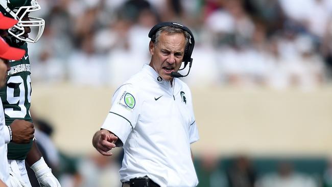 Mark Dantonio talks to a player on the sidelines in their match against the Wisconsin Badgers.