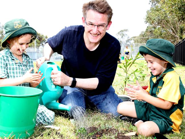 Jon Dee plants trees with school studnets.