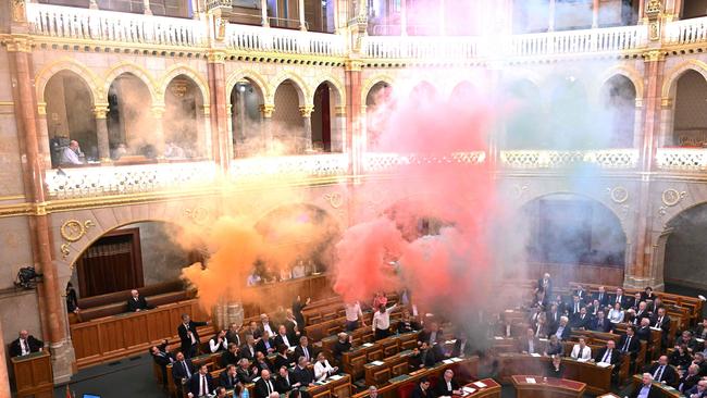 Members of the centrist Momentum Movement party burn flares in protest before a vote on a bill aimed at banning the annual Pride march. Picture: AFP