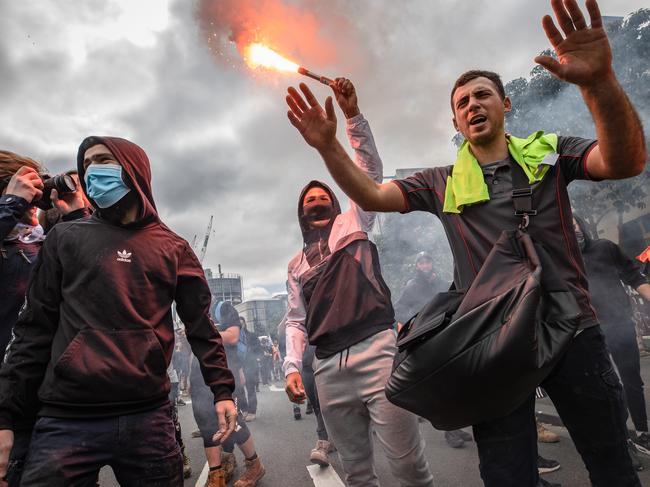 Angry protesters let off flares in Melbourne’s CBD. Picture: Jason Edwards