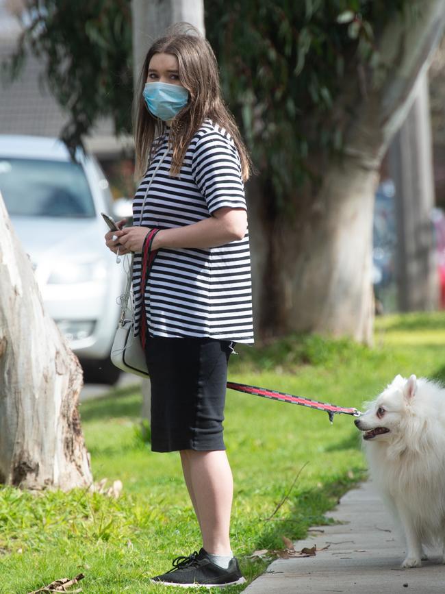 A local girl drops off flowers at the site where Ayan was struck by the tree. Picture: Tony Gough