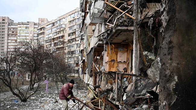 A man clears debris at a damaged residential building at Koshytsa Street, a suburb of the Ukrainian capital Kyiv, where a military shell allegedly hit. Picture: AFP