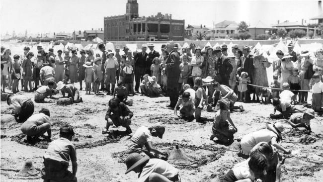 A judge dressed in a suit watches the  sandcastle competition at Semaphore, 1946.