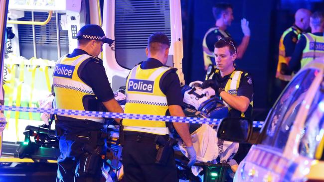 Police stand close as the man is placed in the back of an ambulance on City Road. Picture: Patrick Herve