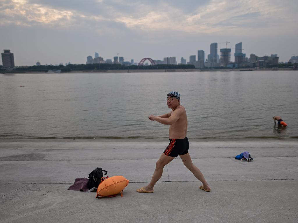 A man warms up before swimming in the Yangtze River in Wuhan. Picture: Hector Retamal