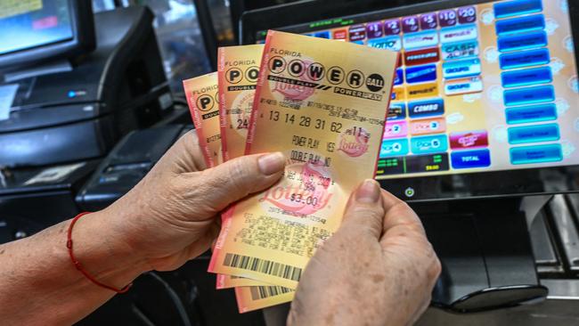 A woman holds Powerball lottery tickets inside a store in Florida. The $1 billion jackpot was won by a single ticket holder on Thursday. Picture: Giorgio Viera / AFP.